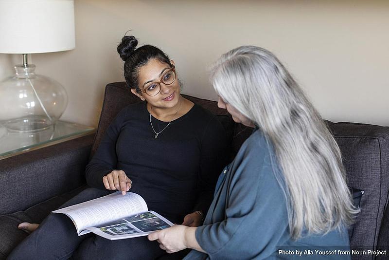 Woman and carer reading together